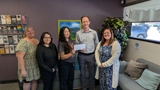 SLVFB employees presenting a We Care, We Share donation to Tu Casa