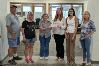 SLVFB employees presenting a We Care, We Share donation to Alamosa High School Wrestling Team