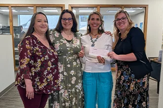 SLVFB employees presenting a We Care, We Share donation to Kid's Place Of the San Luis Valley